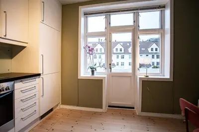 a kitchen with a window with a vase of flowers on the counter at Quiet place near city centre and the mountains in Bergen