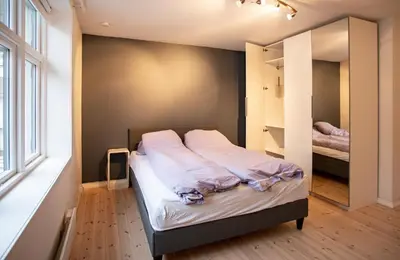 a bedroom with a bed and a large window at Quiet place near city centre and the mountains in Bergen