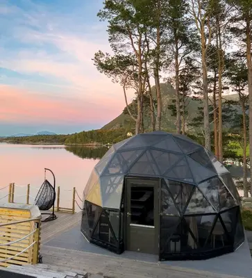 a tent on a dock next to a lake at A little corner of paradise in Molde