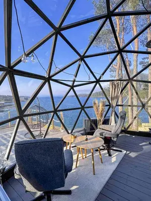 a glass house with a view of the ocean at A little corner of paradise in Molde