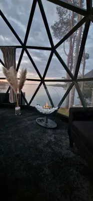 a room with a view of the water and a fire pit at A little corner of paradise in Molde