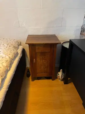 a small wooden table next to a bed in a room at Ålesund Central Apartment in Ålesund