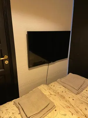 a bedroom with a bed with a flat screen tv on the wall at Ålesund Central Apartment in Ålesund