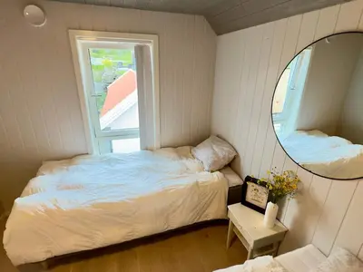 a small bedroom with a bed and a mirror at 6 person holiday home in Huglo in Nordhuglo