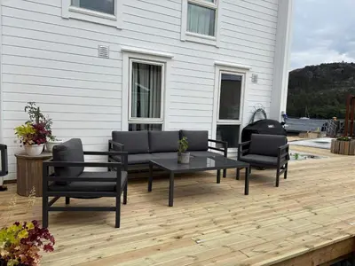 a patio with a table and chairs on a wooden deck at 6 person holiday home in Huglo in Nordhuglo