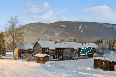 a house in the snow with a mountain in the background at Hafjell Alpinlandsby in Hafjell