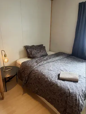 a bedroom with a bed and a table with a lamp at Hafjell Alpinlandsby in Hafjell