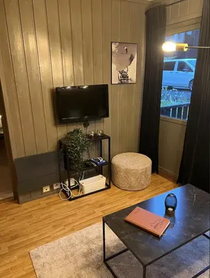a living room with a television and a table at Hafjell Alpinlandsby in Hafjell