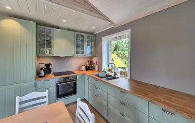 a kitchen with blue cabinets and a table and a window at 3 Bedroom Awesome Home In Rossland in Rossland