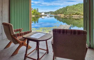a table and chairs on a porch with a view of a river at 3 Bedroom Awesome Home In Rossland in Rossland