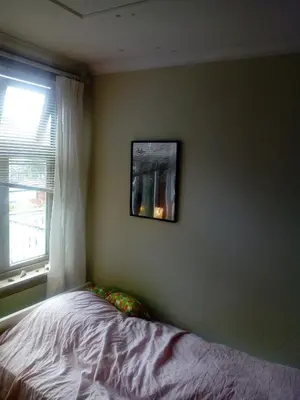 a bedroom with a bed and a picture on the wall at Room2B in Bergen