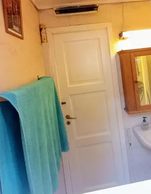 a bathroom with a blue towel hanging on a door at Room2B in Bergen