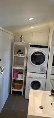 a laundry room with a washing machine and a shelf at Cottage in Hellesøy, Øygarden in Hellesøy