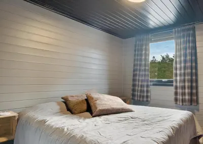 a bedroom with a bed and a window in it at Mortenhytta, Valevåg in Valevåg