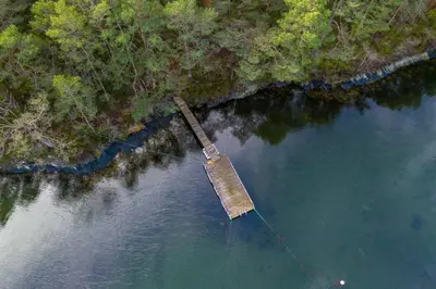an old dock in the middle of a body of water at Mortenhytta, Valevåg in Valevåg