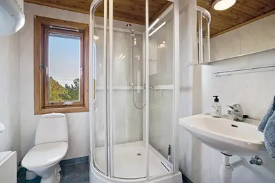 a bathroom with a shower and a toilet and a sink at Mortenhytta, Valevåg in Valevåg