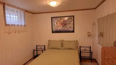 a bedroom with a bed and a picture on the wall at Garsoniera in Leirvåg