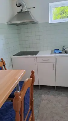 a small kitchen with a table and a sink at Garsoniera in Leirvåg