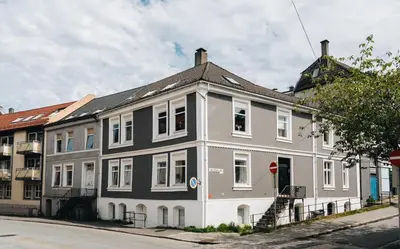 a white and gray building on the side of a street at Leilighet Bergen Sandviken in Bergen