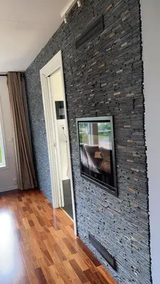 a room with a brick wall with a tv on it at Helt hus leies ut under fiskeri messe 2025 in Trondheim