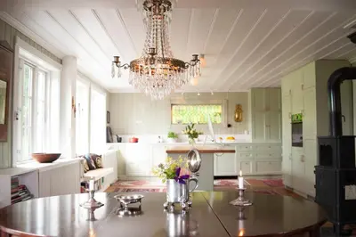 a large kitchen with a table and a chandelier at Villa Solås in Lillehammer