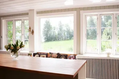 a large kitchen with windows and a table at Villa Solås in Lillehammer