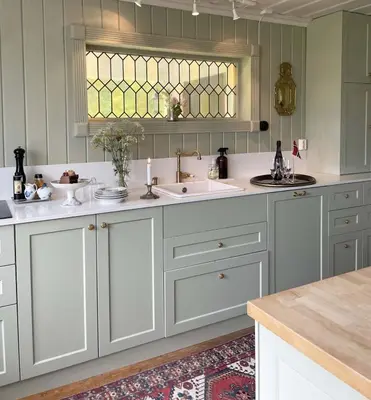 a kitchen with white cabinets and a sink and a window at Villa Solås in Lillehammer
