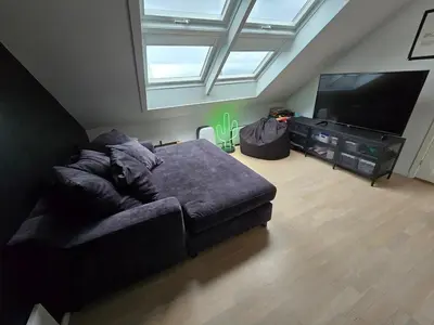 a living room with a couch and a flat screen tv at Sentrumsidyll ved fjord og fjell in Molde