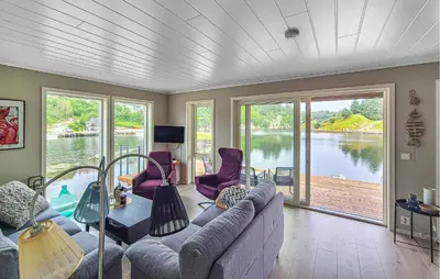 a living room with a couch and a table at Amazing Home In Bremnes With Wifi in Bremnes