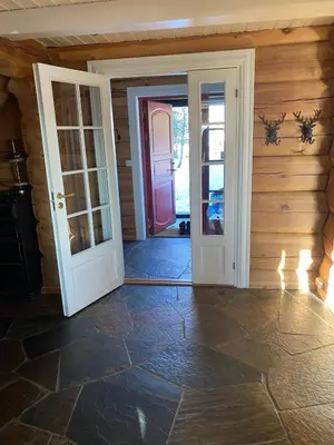 an open door in a room with a door at Stor velutstyrt laftehytte med usjenert uteplass, flott utsikt og Jacuzzi in Eggedal
