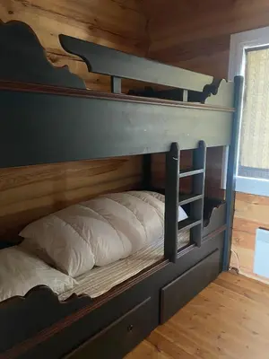 a bunk bed in a room with wooden walls at Stor velutstyrt laftehytte med usjenert uteplass, flott utsikt og Jacuzzi in Eggedal