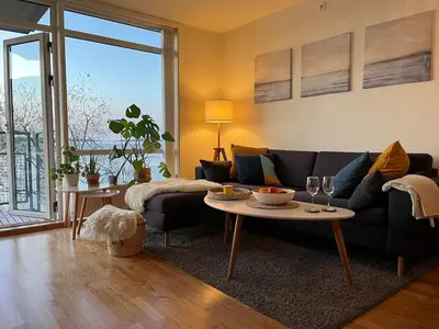 a living room with a couch and a table at Exclusive flat with amazing view over the fjord in Trondheim