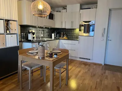 a kitchen with a wooden table with chairs and a dining room at Exclusive flat with amazing view over the fjord in Trondheim