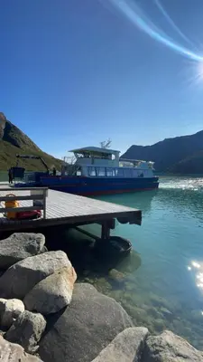 a boat is docked at a dock in the water at Stor tømmerhytte med fjellutsikt in Beitostøl
