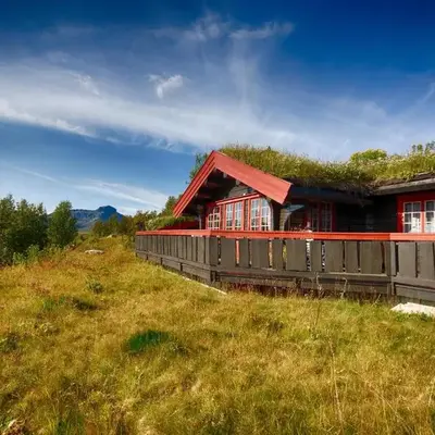 Stor tømmerhytte med fjellutsikt