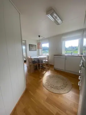a kitchen and dining room with a table and chairs at Haraldseidvågen gjestgjevarstad in Skjold