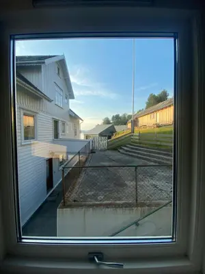 a window with a view of a building at Haraldseidvågen gjestgjevarstad in Skjold