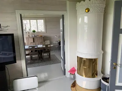a living room with a fireplace and a dining room at Flø Feriehus med Badstue in Ulstein
