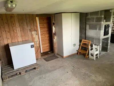 an empty room with a refrigerator in a house at Flø Feriehus med Badstue in Ulstein