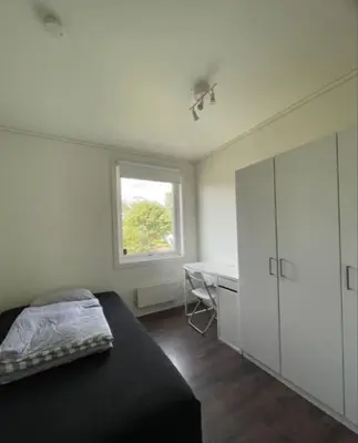a bedroom with a bed and a desk and a window at Alfred Apartment in Trondheim in Trondheim