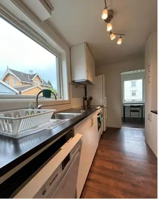 a kitchen with a sink and a large window at Alfred Apartment in Trondheim in Trondheim