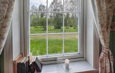 a window with a candle and books on a window sill at Stunning Home In Engerdal With Wifi in Nymoen