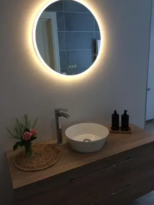 a bathroom with a sink and a mirror on a counter at Gårdsleilighet in Verdal