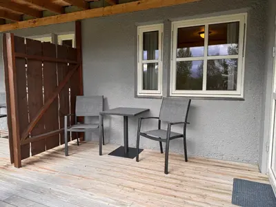 a patio with two chairs and a table and a window at Høvringen Lodge in Høvringen