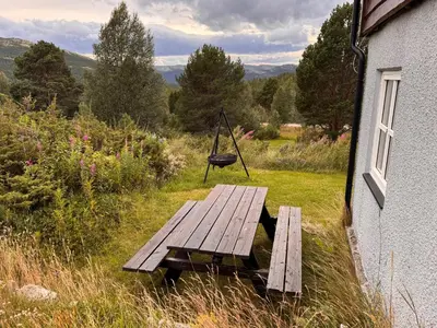 a picnic table outside of a house with a swing at Høvringen Lodge in Høvringen
