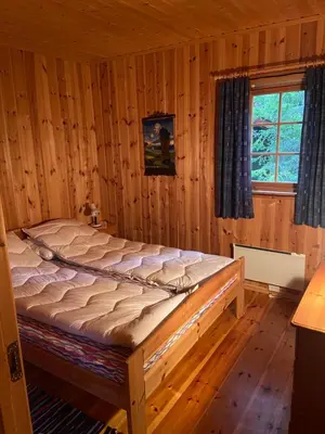 a bedroom with a bed in a wooden room at Det er en fantastisk og romslig hytte i Slemdalen, Nordre Osen! in Åmot
