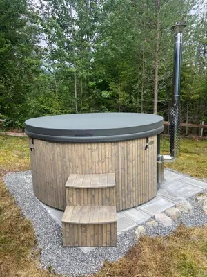 a hot tub with two benches in a yard at Det er en fantastisk og romslig hytte i Slemdalen, Nordre Osen! in Åmot