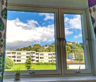 a window with a view of a building at Private Room in a shared Apartment with Mountain Views & Greenery in Trondheim