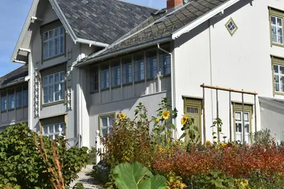 a white house with a garden in front of it at Steien Hotel in Alvdal