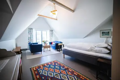 a bedroom with a bed and a living room at Steien Hotel in Alvdal